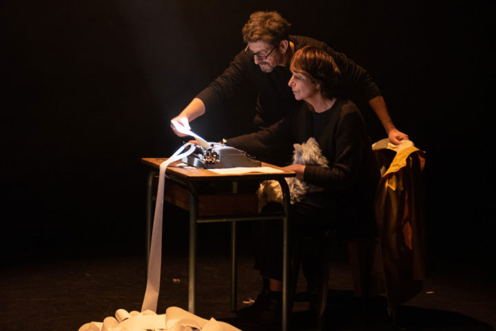 photo de deux personnages devant une machine à calculer ancienne